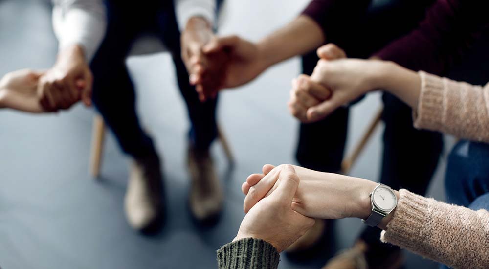 Members of a counseling circle hands as they discuss military sexual trauma