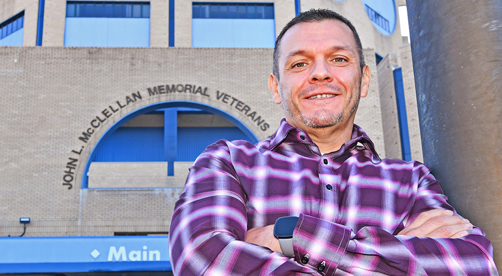 Liver transplant Veteran in front of VA hospital